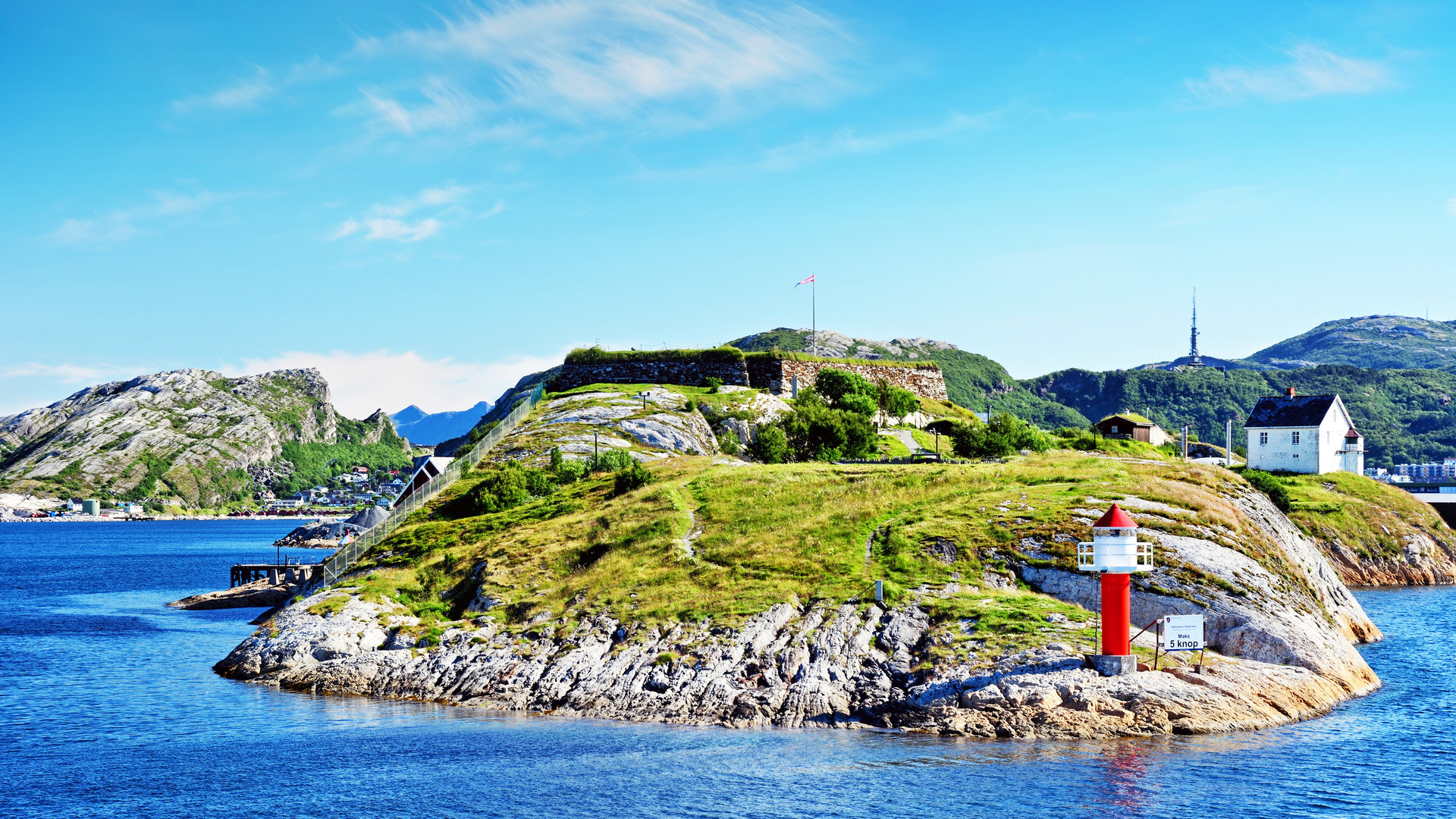 Et fyr omgitt av klart blått vann i Bodø